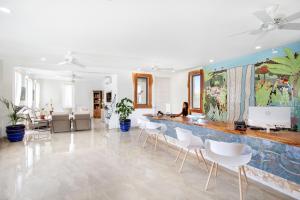 a room with a counter with white chairs and a wall at Beach View Hotel in Saint James