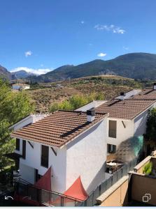 vistas a un edificio con montañas en el fondo en La Casa del Pianista, en Monachil