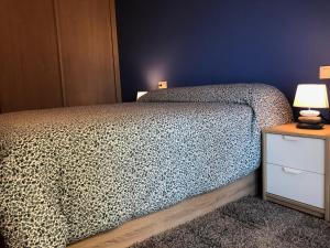 sypialnia z łóżkiem i stołem z lampą w obiekcie Costa Da Morte Deluxe w mieście Malpica