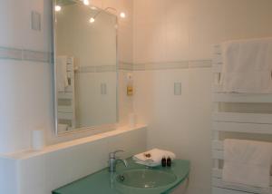 y baño con lavabo, espejo y toallas. en Le Petit Cochon, en Valence-sur-Baïse