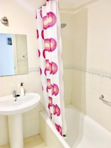 a bathroom with a sink and a shower curtain at Apartment Aguila Real in Mijas Costa