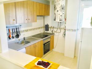 a kitchen with wooden cabinets and a sink and a refrigerator at Apartment Aguila Real in Mijas Costa