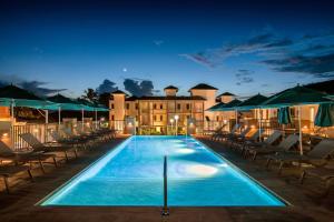 a swimming pool with chairs and a building at night at Beach View Hotel in Saint James