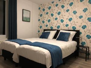 a bed room with a blue and white bedspread at Mimosa Hotel in Valkenburg