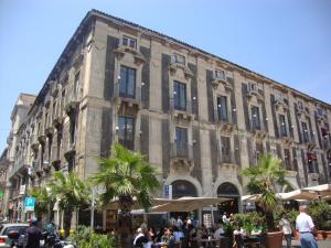 a large building with people sitting outside of it at Tre Stelle al Duomo in Catania