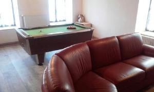 a living room with a couch and a pool table at aux genets de josephine in Fournols