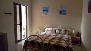 una camera da letto con un letto in una stanza con una finestra di Rubis a Victoria