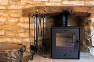 a brick wall with a stove in a room at Cotswold Place in Cirencester