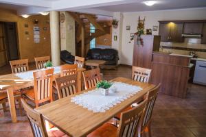 a dining room and kitchen with wooden tables and chairs at Noclegi u Kiesza in Ustrzyki Dolne