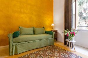 ローマにあるSantonofrio Apartmentsの黄色の壁の部屋の緑のソファ