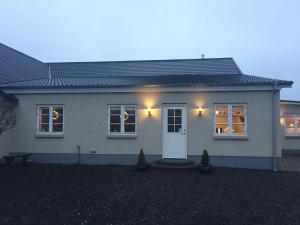 a white house with two windows and a door at Lykkebjerg in Varde