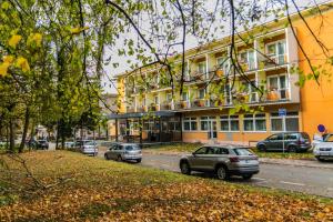 a street with cars parked in front of a building at Hotel Rezident in Turčianske Teplice