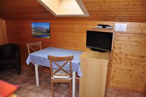 een eetkamer met een tafel en een tv in een hut bij Chalet Allmegrat in Adelboden