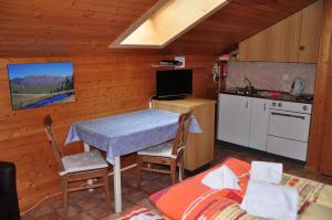 a room with a table and a kitchen with a bed at Chalet Allmegrat in Adelboden