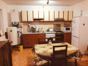 a kitchen with a table and a white refrigerator at Villa Melania in Azuga