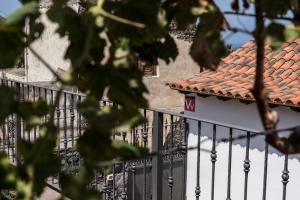 a white building with a red roof and a fence at San Borondón in Alojera