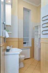 uma casa de banho com um lavatório branco e um WC. em Sunflower B&B em Kiev