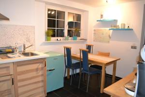 a kitchen with a wooden table and blue cabinets at Fewo Grenzach in Grenzach-Wyhlen