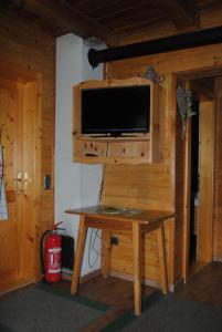 Untere Roner Kasa في Mörtschach: غرفة مع طاولة وتلفزيون على الحائط