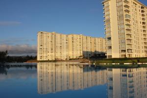 a large apartment building next to a body of water at Resort Laguna Bahía, Océano Piso 12 Algarrobo in Algarrobo