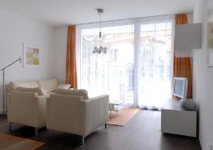 - un salon avec un canapé et une télévision dans l'établissement Apartment Topas, à Zermatt