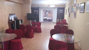 Habitación con sillas y mesas rojas y TV. en Hotel Corona de Castilla, en Villares de la Reina