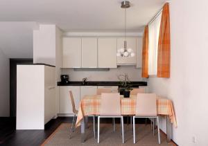 a kitchen with a table and some white cabinets at Apartment Topas in Zermatt