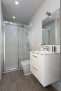 a white bathroom with a shower and a toilet at Torres del Sol in Arona