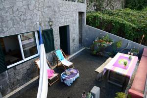 vistas panorámicas a un patio con mesa y sillas en Janela para o Atlântico en Porto Moniz
