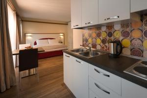 una cucina con lavandino e una camera con letto di Casa da Vito a Bad Kissingen