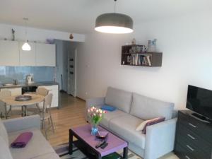 uma sala de estar com um sofá e uma mesa em Apartament Morskie Polanki em Kolobrzeg