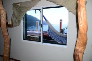 a window with a hammock looking out at the ocean at Janela para o Atlântico in Porto Moniz