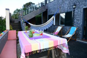 a table with a colorful table cloth on a patio at Janela para o Atlântico in Porto Moniz