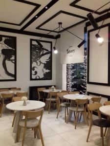 a dining room with white tables and chairs at Hotel Story in Sarajevo