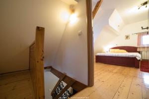 um quarto com uma cama e piso em madeira em Snežna Kuća Apartments em Kopaonik