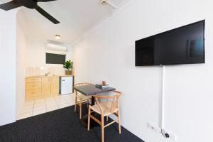 a living room with a table and a tv on a wall at Hotel Forster in Forster
