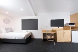 a hotel room with a bed and a desk and a tv at Hotel Forster in Forster