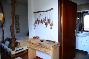 ポルト・モニスにあるJanela para o Atlânticoのテーブルと壁に骨を付けたベッドが備わる客室です。