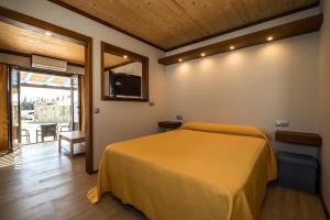 - une chambre avec un lit jaune et une porte coulissante en verre dans l'établissement El Caseron de Conil & Spa, à Conil de la Frontera 122 autres photos