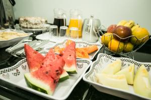 a table with three plates of watermelon sandwiches and fruit at Hotel Folley in Toledo