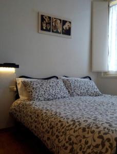 ein Schlafzimmer mit einem Bett mit einer Bettdecke und einem Fenster in der Unterkunft Il Vecchio Portico in Cesena