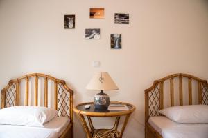 a bedroom with two beds and a table with a lamp at Petra Traditional House in Episkopión