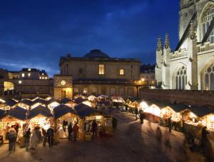 a group of people walking around a christmas market at night at Cotswold Place in Cirencester