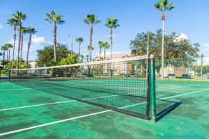 a tennis net on a tennis court with palm trees at Disney Adjacent in Kissimmee