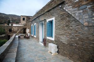 a stone building with a blue door and windows at Petra Traditional House in Episkopión