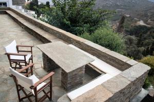 a patio with two chairs and a stone fireplace at Petra Traditional House in Episkopión