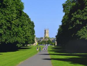 a group of people walking down a path in front of a building at Cotswold Place in Cirencester