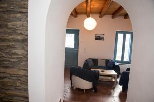 a living room with a table and chairs and a stone wall at Petra Traditional House in Episkopión