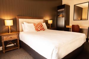 a bedroom with a large white bed and two lamps at Nightcap at Archer Hotel in Nowra