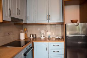 a kitchen with white cabinets and a stainless steel refrigerator at Petra Traditional House in Episkopión